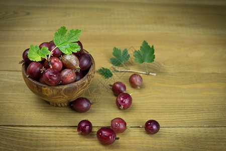 红莓果子在一个木碗里在木质背景上是图片