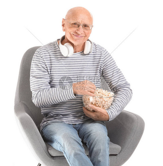 白色背景中戴耳机和爆米花的老人肖像图片