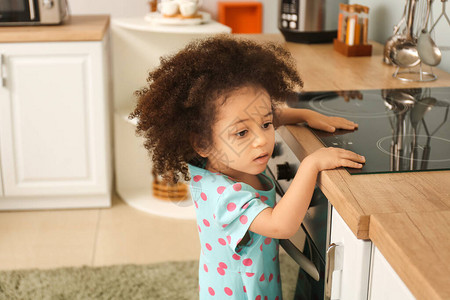 非裔美国女孩在厨房玩炉灶处境危险的儿图片