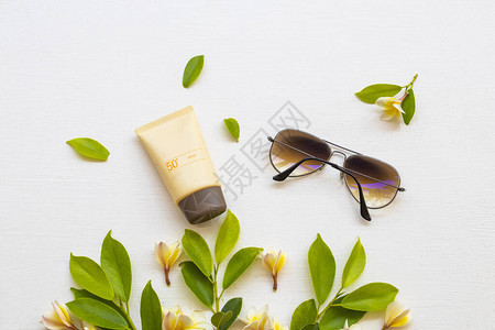 为皮肤脸部太阳眼镜和黄色花朵提供健康保健的化妆品图片