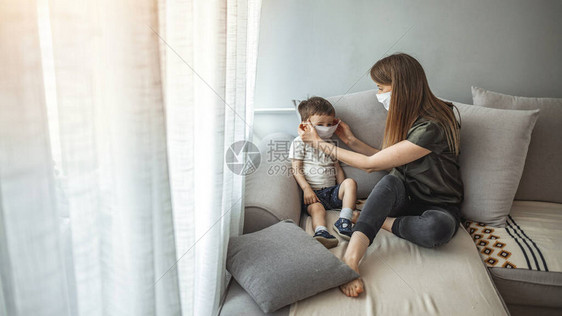 母亲给她的孩子戴上口罩保健概念预防传染病和流感的防护医用口罩冠状大流行期间母亲和孩子图片