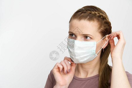 戴着医用口罩的女人蒙面妇女预防流感家里戴防护面罩的耳朵阻止和流行病图片