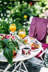 Alfresco外面的早餐里有鸡蛋咖啡果汁羊角面包和白桌上的浆果图片