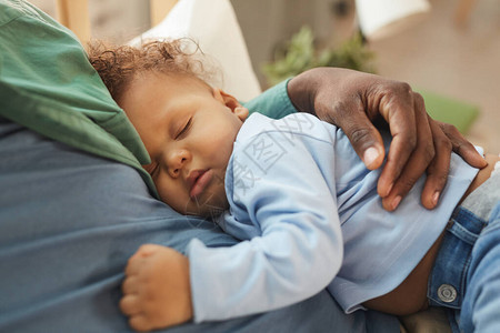 睡在父亲怀抱中的可爱的混合种族婴儿图片