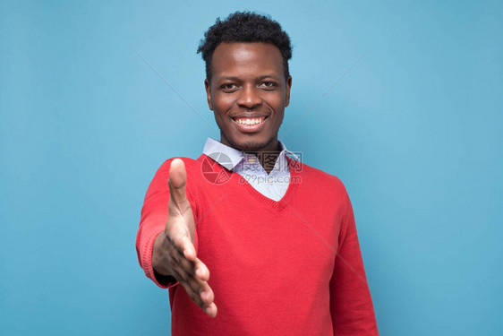 年轻的非洲美国人向相机伸出双手握用蓝图片