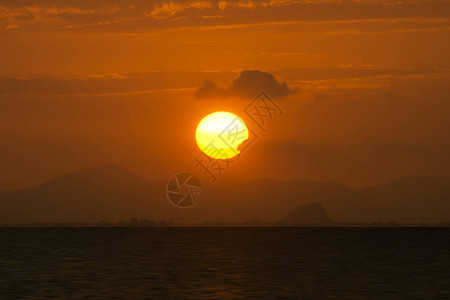 落日天空中的大太阳淹没在山后图片