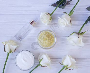 化妆品霜木制背景上的玫瑰花图片