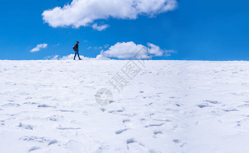 一个背包女人走在雪山的风景高清图片