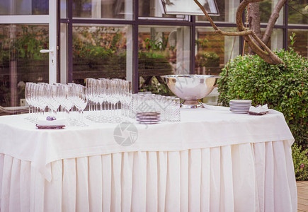 节日餐桌布置户外空杯子和盘子露台上的宴会大自然中的餐图片