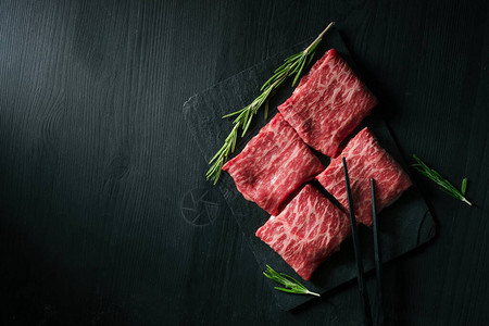 黑底日本肉品顶视和复制空间板上的八头牛肉图片