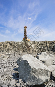 花岗岩采石场边缘的一台巨大钻机前景是一块巨图片