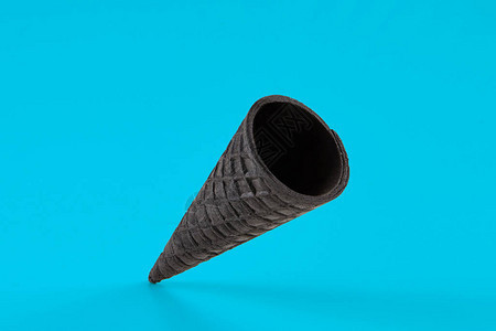 蓝色背景下冰淇淋用的空松脆的黑色薄饼锥食物和款待的概念样机图片