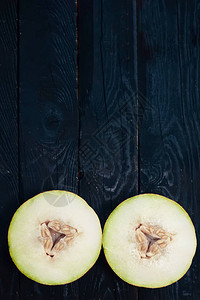 深色木质背景上的甜有机夏瓜片在木头上切成熟的瓜从上面查看顶视图片