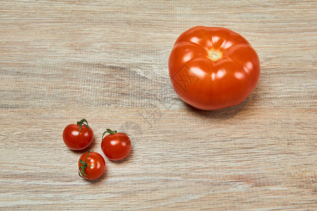 3个小樱桃西红柿旁边是桌上的一图片