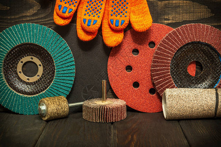 黑色复古木板向导上的一组研磨工具和橙色工作手套图片