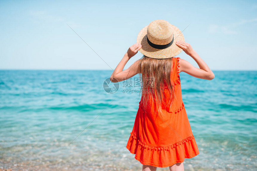 可爱的小女孩在卵石沙滩上浅水中图片