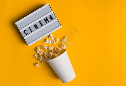 花瓶里的爆米花和文字CINEMA在黄色背景的白色图片