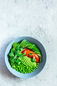 新鲜蔬菜黄瓜西红柿青豆生菜放在蓝色背景的碗里图片