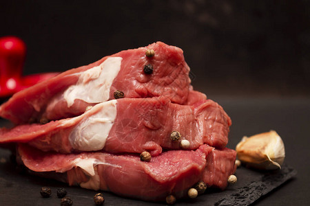 石板上的大理石小牛肉的生肉彼此叠放在深色图片素材