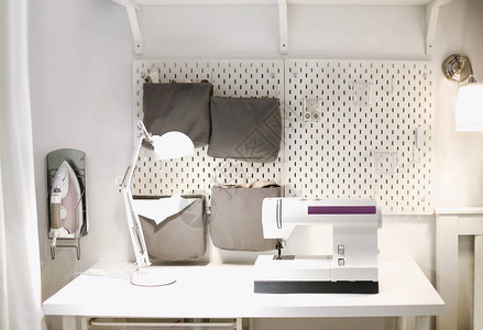 缝纫机放在裁缝车间的桌上有灯和缝纫配图片