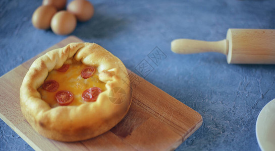 深迪什比萨薄饼奶酪干樱桃西红柿木板上的食物滚动针和鸡蛋芝士原料图片