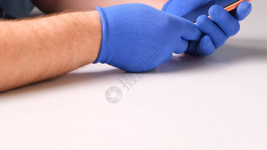 戴着蓝色手套的男手代替了智能手机破碎的钢化玻璃屏幕保护膜一个男人准备用智能手机代替玻璃智能手机维修理图片