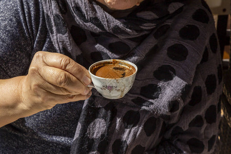 拿着传统瓷土耳其咖啡杯的妇女手图片