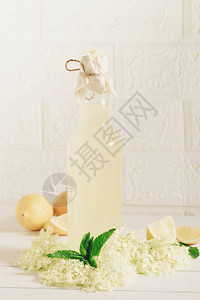 一瓶自制的接骨木柠檬水和新鲜采摘的接骨木花图片