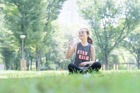 亚洲年轻女子在公园做瑜伽时补水图片