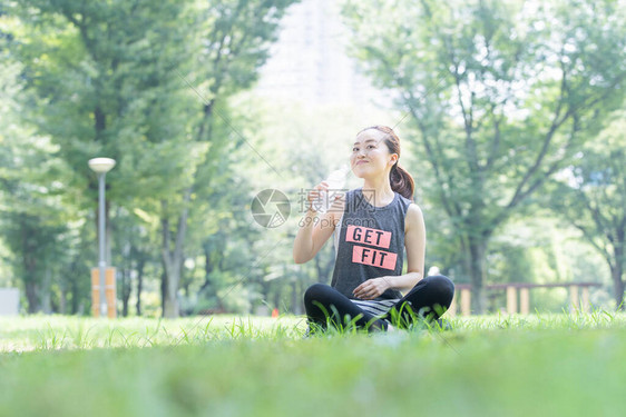 亚洲年轻女子在公园做瑜伽时补水图片