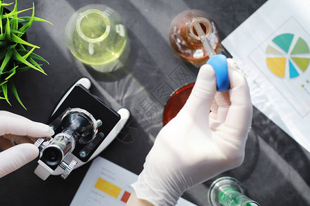 实验室研究药物测试在实验室进行化学实验在医务人员的桌子上用显微镜观察各图片