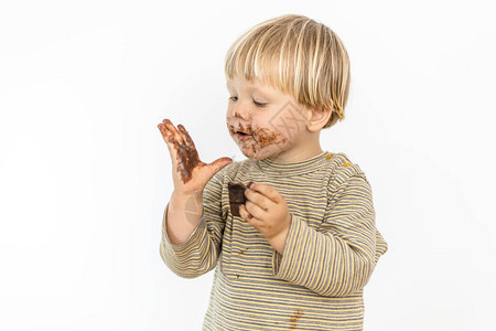 金色可爱的小孩快乐地吃巧克力棒孤立在白色图片