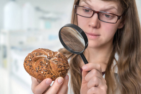 科学家用放大镜检查凯撒面包食品中不健图片