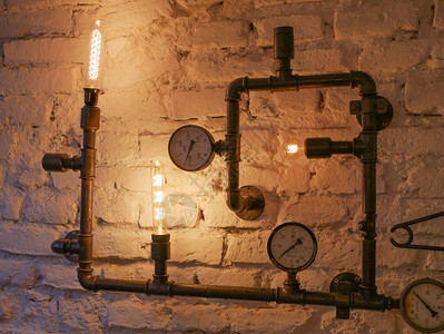 蒸汽朋克装饰用铁管和白炽灯阁楼风格的墙壁和蒸汽朋克管背景图片