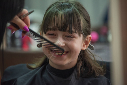 院概念小女孩在理发店剪刘海剪发9岁的女孩在一家美图片