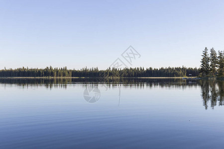 在一片平静的蓝水湖中海岸的花环被反映出来晴朗的白天图片