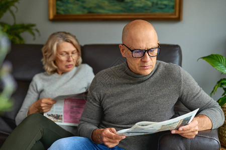 成人妇女和男子阅读报纸新闻报刊媒体节假图片