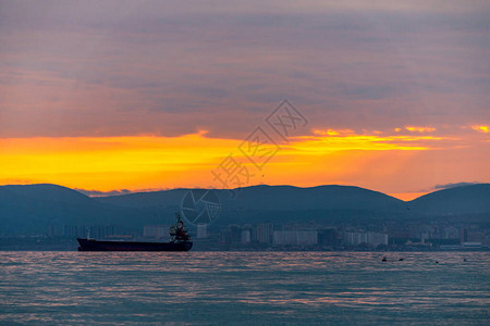 货船在的日落或日出时在海上航行太阳落山或升起时跨水海运大自然的和谐与美丽风景秀图片