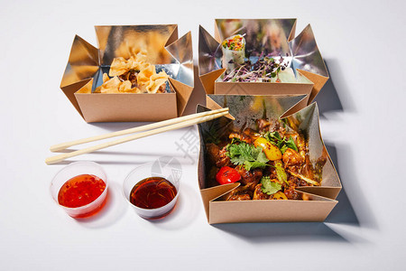 辣椒酱和筷子靠近外卖盒的烤箱配背景图片