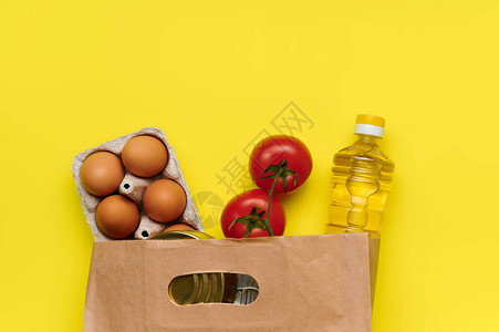 鸡蛋西红柿罐头食品黄色背景纸袋中的油图片