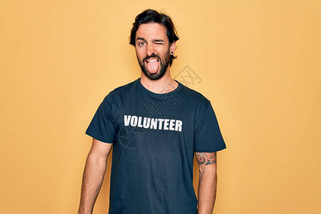 年轻英俊的西班牙裔志愿者穿着志愿T恤作为社会关怀图片