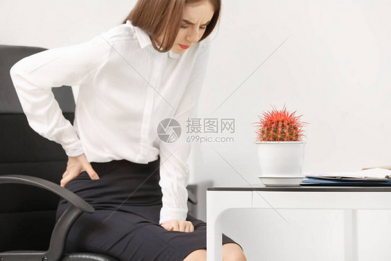 在办公室有痔疮的年轻女商人图片