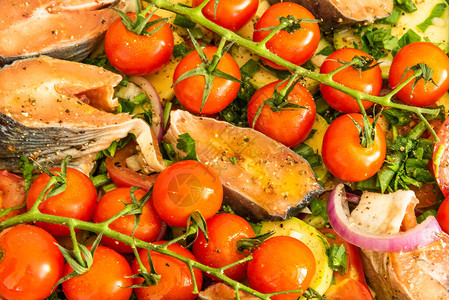 将生蔬菜和鱼块塞在用鳟鱼煮菜烤熟的炖图片