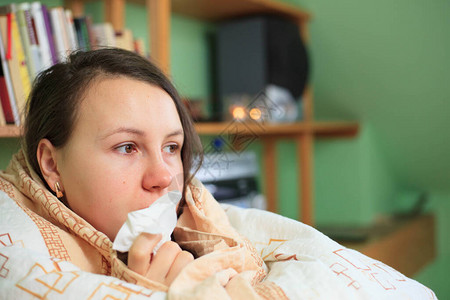 漂亮的年轻黑发美女用白手帕抽鼻涕图片素材