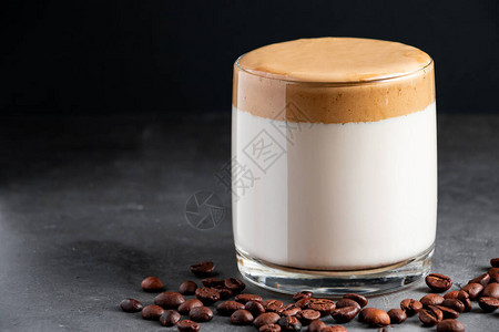 黑色背景的达尔戈纳咖啡一杯由牛奶和荧光泡沫制成的图片