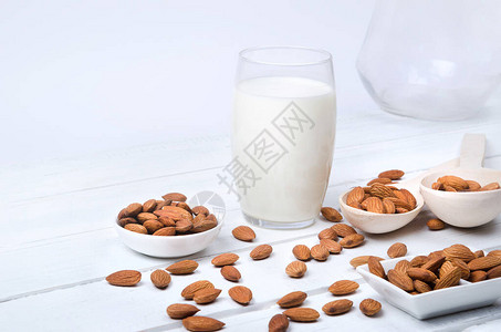 燕麦牛奶与木制背景上的燕麦种子素食图片