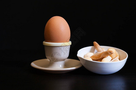 鸡蛋和陶瓷碗中软煮蛋黑底的面包图片