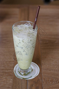 木桌上玻璃杯中的冰绿茶背景图片
