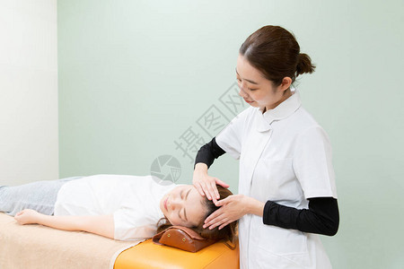 亚洲女执业医师对女患者的头部和图片