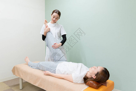 亚洲女执业医师按摩一名女病人的图片